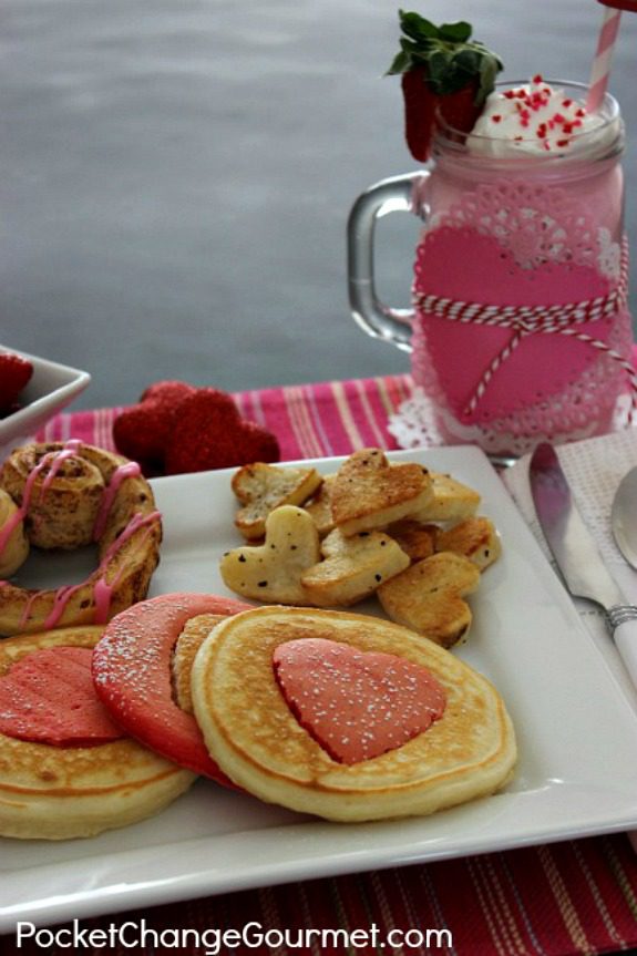 Valentine's Day Breakfast - complete with heart shaped pancakes, heart cinnamon rolls, heart potatoes, fruit and strawberry milk! Pin to your Recipe Board!