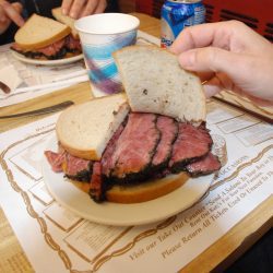 Couple Eating a Pastrami sandwich on a Restaurant