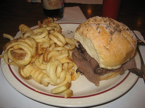 Beef on Weck Kaiser Roll with curly fries on a plate