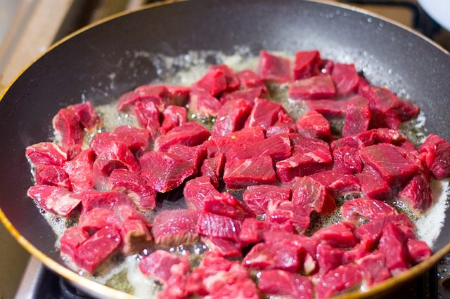a pan of sliced beef to be used for the beef chow mein