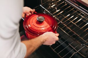 person holding red cook pot