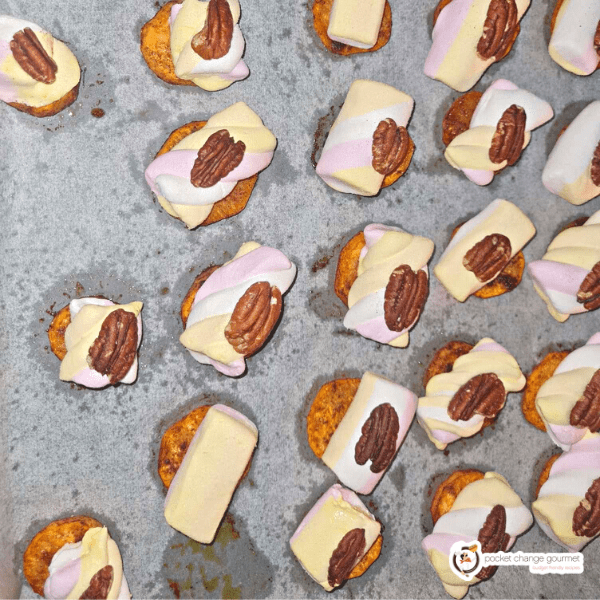 sweet potato bites with marshmallow and pecans in a white sheet tray