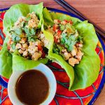 two Asian turkey lettuce wraps on a plate with dipping sauce