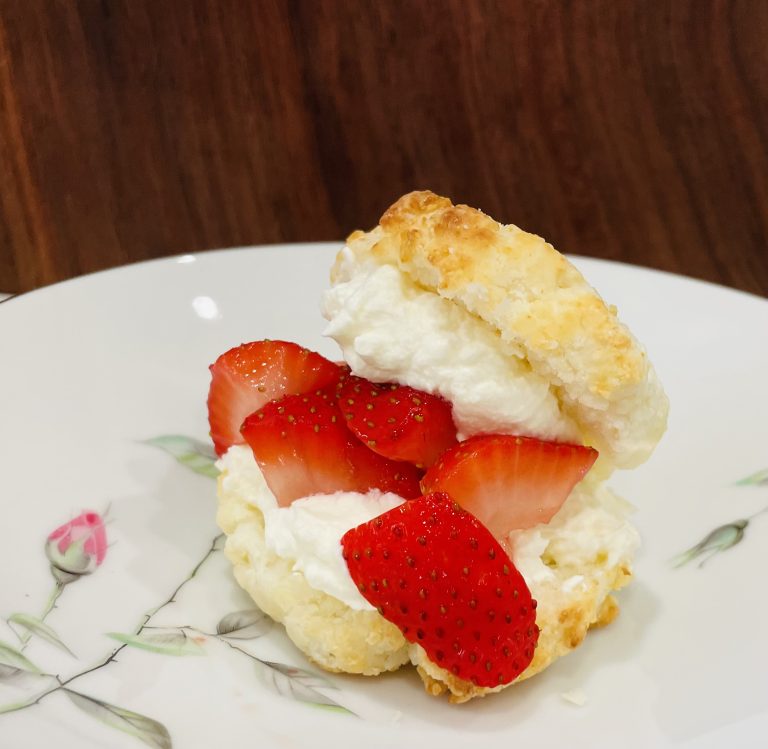 A fluffy Gluten-Free Shortcake is stuffed with strawberries and whipped cream.