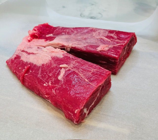 large beef flank steak cut in half