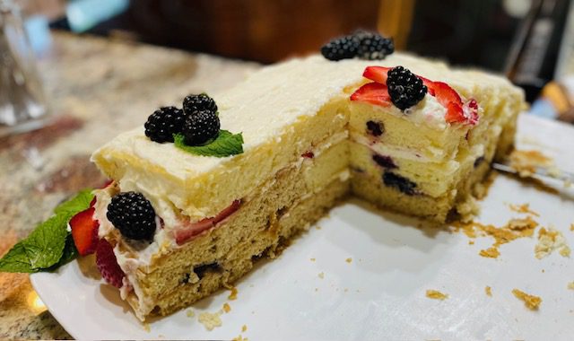 layers of vanilla cake with layers of berries and whipped cream frosting