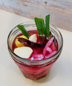 jar of pickled red onions with garlic, chili, ginger, scallion