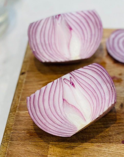 halved red onion on cutting board