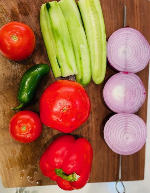 red onion, English cucumber, ripe tomatoes, peppers on cutting board